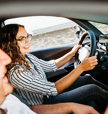 Fahrlehrer und Fahrschülerin im Auto