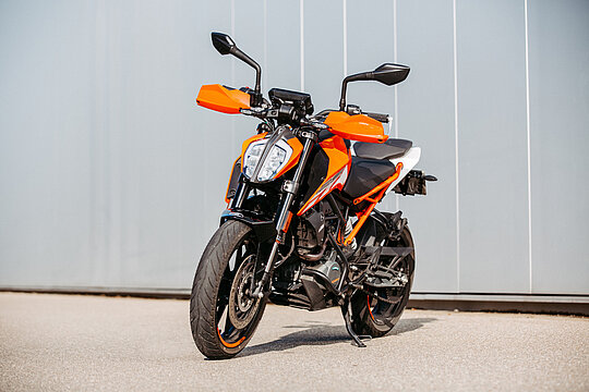 Orangene KTM Duke vor Fahrschule Wollensak