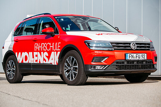 Roter VW Tiguan im Corporate Design der Fahrschule Wollensak 