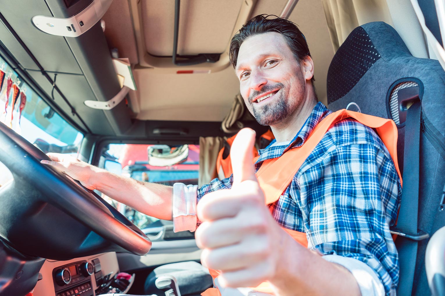 Fröhlicher LKW-Fahrer mit Daumen hoch